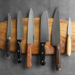 6 modelos diferentes de facas em cima de uma tábua
